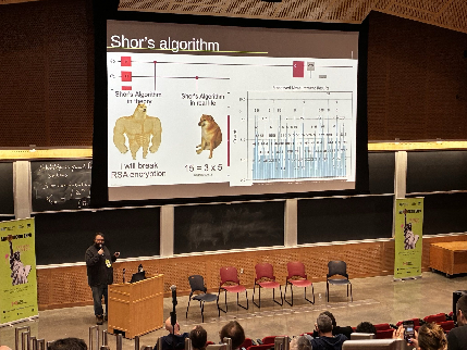 Speaker presenting a slide about Shor’s algorithm in an auditorium